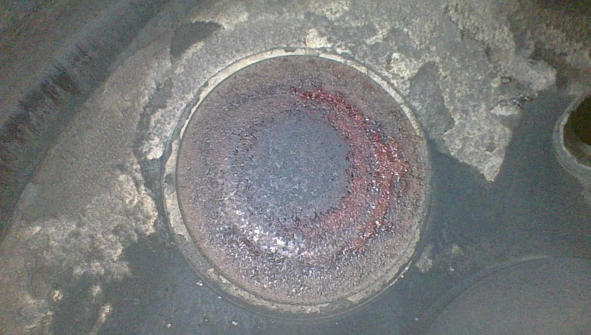 Borescope view of a healthy exhaust valve face showing an even, concentric bullseye pattern