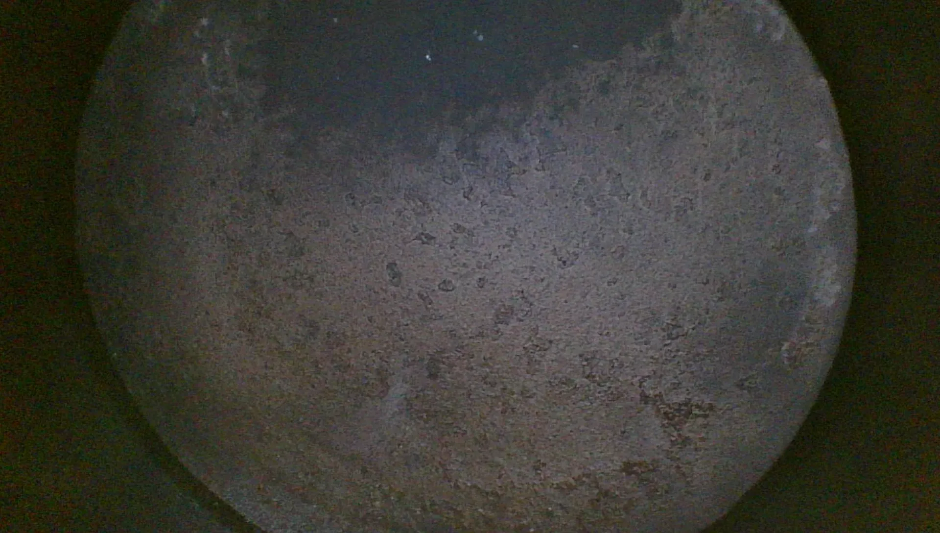 Borescope view of an average piston crown with even gray-tan combustion deposit