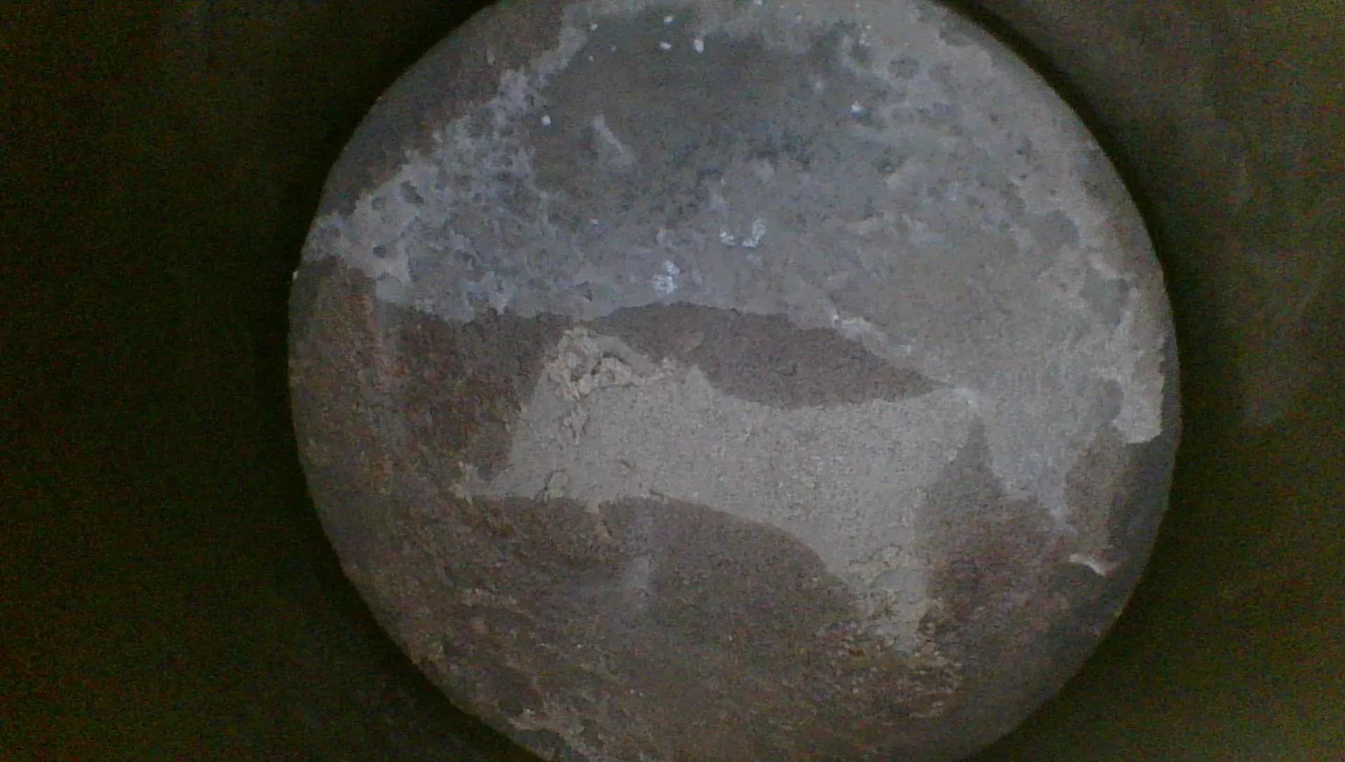 Borescope view of a poorer piston crown with heavier, uneven, scrubbed deposits
