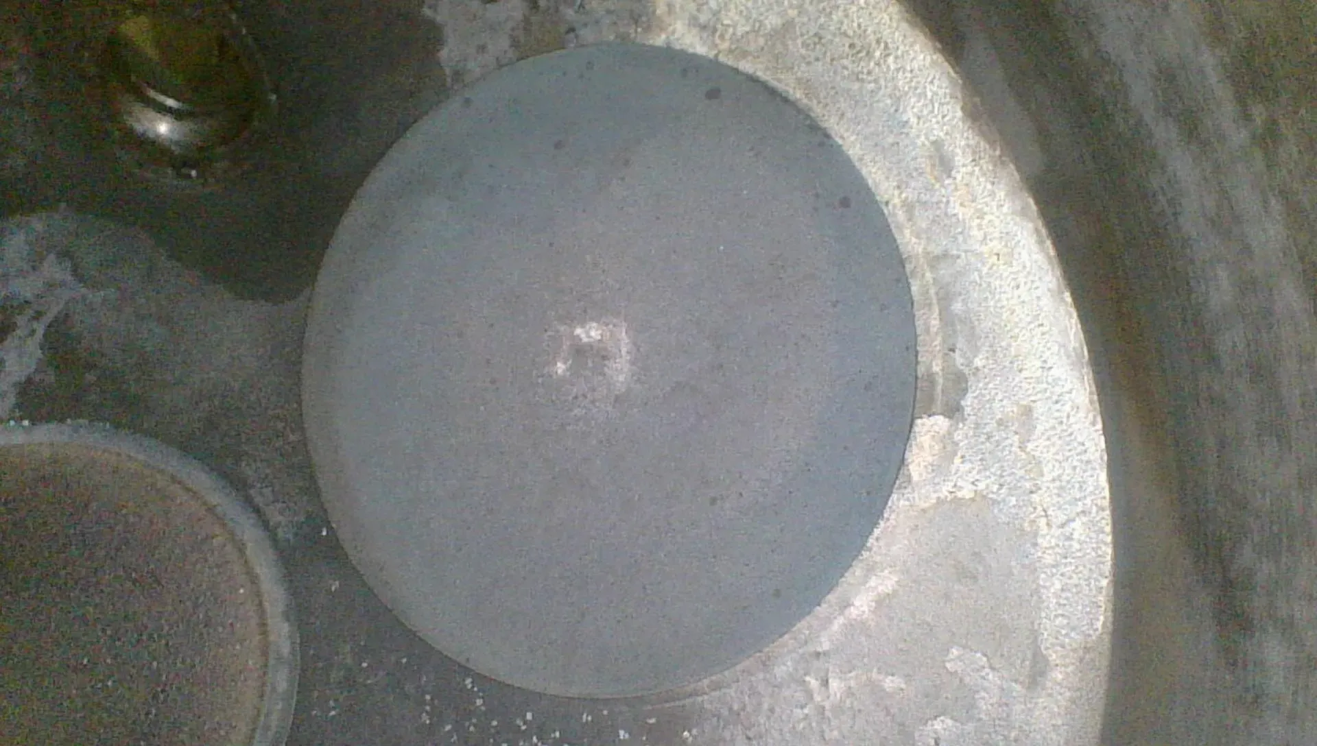 Borescope view of the closed intake valve face, cleaner and grayer than the exhaust
