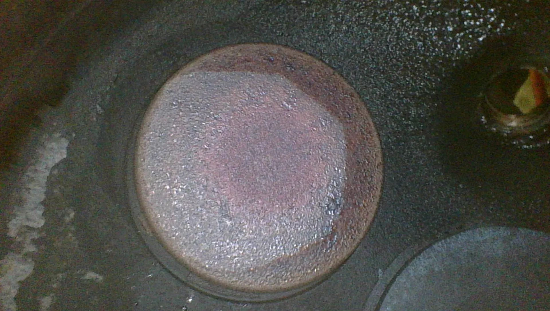 Borescope view of a healthy exhaust valve face showing an even concentric bullseye pattern