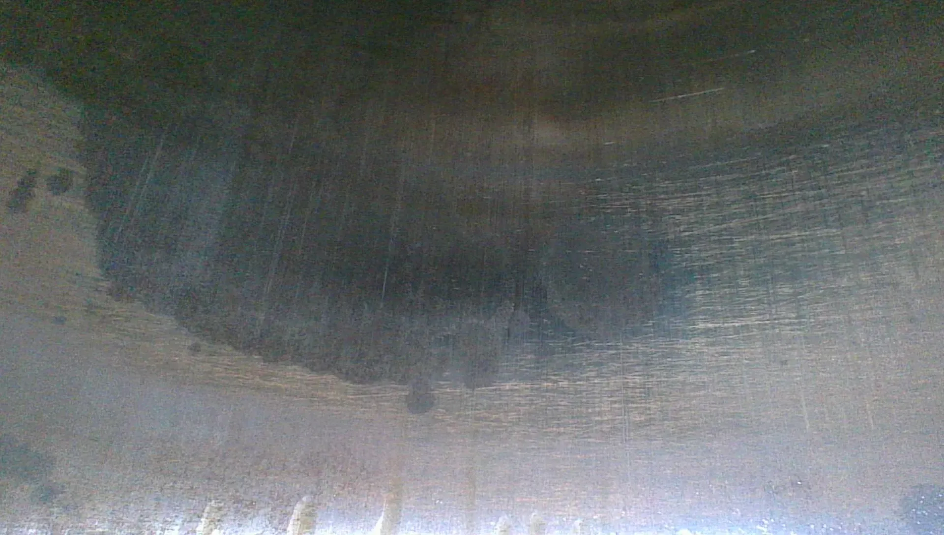 Borescope view of a cylinder wall with the cross-hatch honing pattern faded to a faint ghost