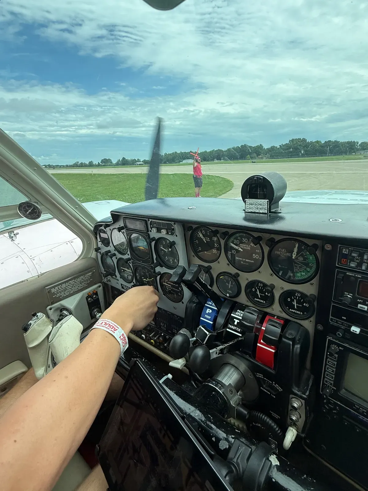 A volunteer marshaller directing the Baron to its parking spot, seen over the instrument panel